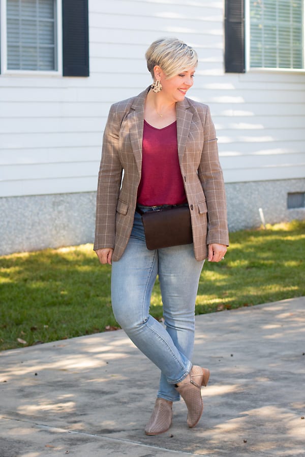 A brown plaid blazer styled with light wash jeans. 