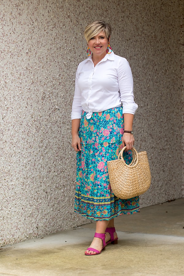 Knot a white button up shirt at the waist with a midi skirt.