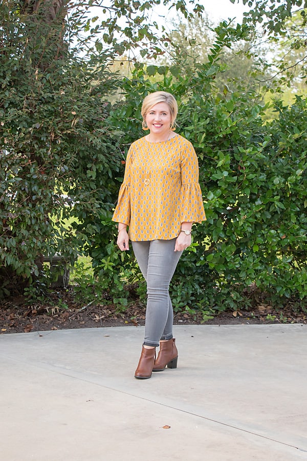 mustard top with grey jeans